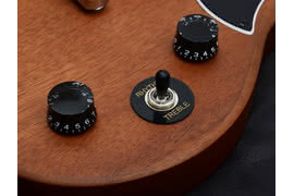 Trójpozycyjny przełącznik umieszczono pomiędzy potencjometrami głośności i barwy z czarnymi, półprzezroczystymi gałkami.